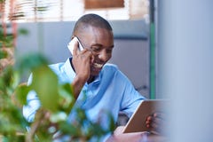 Homme de sourire parlant sur son téléphone portable à un café de trottoir Photo stock