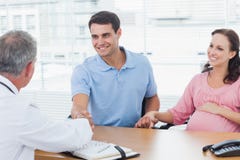 Homme de sourire serrant la main à son docteur tout en tenant son expe images libres de droits Homme de sourire serrant la main à son docteur tout en tenant son expe images libres de droits