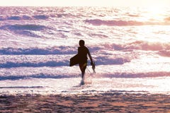 Homme de surfer à la plage au coucher du soleil images libres de droits Homme de surfer à la plage au coucher du soleil images libres de droits