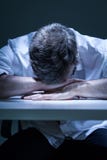 Homme déprimé avec la tête sur la table photographie stock Homme déprimé avec la tête sur la table photographie stock