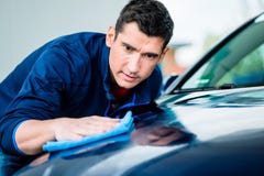 Homme employant une serviette absorbante pour sécher la surface d'une voiture images libres de droits Homme employant une serviette absorbante pour sécher la surface d'une voiture images libres de droits