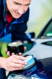 Homme employant une serviette absorbante pour sécher la surface d'une voiture image stock Homme employant une serviette absorbante pour sécher la surface d'une voiture image stock