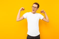 Homme en verres, habillés dans un T-shirt blanc, l'homme qui a gagné des expositions un geste de victoire et de succès, sur un fo image stock Homme en verres, habillés dans un T-shirt blanc, l'homme qui a gagné des expositions un geste de victoire et de succès, sur un fo image stock