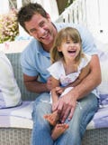 Homme et jeune fille s'asseyant sur rire de patio photographie stock libre de droits Homme et jeune fille s'asseyant sur rire de patio photographie stock libre de droits
