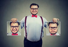Homme gai montrant différentes photos avec des émotions image stock Homme gai montrant différentes photos avec des émotions image stock