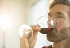 Homme goûtant le vin rouge à la maison Homme goûtant le vin rouge à la maison