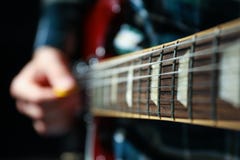 Homme jouant sur la guitare électrique sur le fond foncé images libres de droits Homme jouant sur la guitare électrique sur le fond foncé images libres de droits