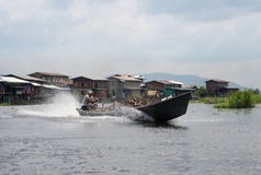 Homme livrant le bois dans le bateau sur le lac d'inle au myanmar photo stock Homme livrant le bois dans le bateau sur le lac d'inle au myanmar photo stock