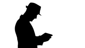 Homme occasionnel de silhouette utilisant le comprim? et le sourire tout en se r?veillant banque de vidéos Homme occasionnel de silhouette utilisant le comprim? et le sourire tout en se r?veillant banque de vidéos