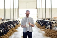 Homme ou agriculteur avec la cruche de lait de vaches à l'exploitation laitière images stock Homme ou agriculteur avec la cruche de lait de vaches à l'exploitation laitière images stock