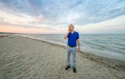 Homme parlant sur le mobile sur la plage Images stock Homme parlant sur le mobile sur la plage Images stock