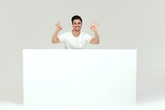Homme posant avec le conseil vide blanc Images libres de droits Homme posant avec le conseil vide blanc Images libres de droits
