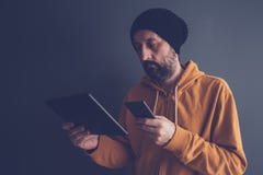 Homme regardant son écran de smartphone et de comprimé photos stock Homme regardant son écran de smartphone et de comprimé photos stock
