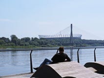 Homme s'asseyant sur une berge de boulevard et appréciant la belle vue au stade de football national images libres de droits Homme s'asseyant sur une berge de boulevard et appréciant la belle vue au stade de football national images libres de droits