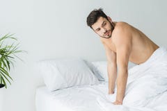 homme sans chemise bel posant sur le lit blanc image libre de droits homme sans chemise bel posant sur le lit blanc image libre de droits