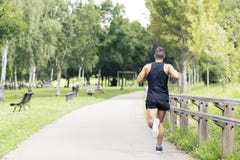 Homme sportif courant et s'exerçant en parc photos libres de droits Homme sportif courant et s'exerçant en parc photos libres de droits