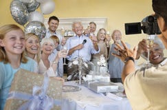 Homme supérieur célébrant le début de la retraite avec la famille et les amis images stock Homme supérieur célébrant le début de la retraite avec la famille et les amis images stock