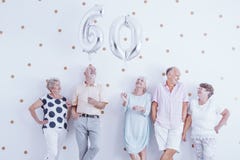 Homme supérieur heureux et femme tenant les ballons argentés photo stock Homme supérieur heureux et femme tenant les ballons argentés photo stock