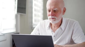 Homme supérieur plus âgé bel travaillant sur l'ordinateur portable à la maison À distance travaillent en indépendants le travail banque de vidéos Homme supérieur plus âgé bel travaillant sur l'ordinateur portable à la maison À distance travaillent en indépendants le travail banque de vidéos
