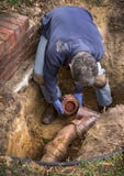 Homme travaillant à vieux Clay Ceramic Sewer Line Pipes photo libre de droits Homme travaillant à vieux Clay Ceramic Sewer Line Pipes photo libre de droits