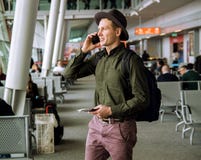 Homme urbain d'affaires parlant au téléphone intelligent à l'intérieur dans l'aéroport photos libres de droits Homme urbain d'affaires parlant au téléphone intelligent à l'intérieur dans l'aéroport photos libres de droits