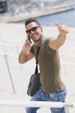 Homme urbain à l'aide des lunettes de soleil de port d'un téléphone dehors image libre de droits Homme urbain à l'aide des lunettes de soleil de port d'un téléphone dehors image libre de droits
