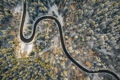 Hommelsatellietbeeld van een windende weg in het midden van het bos met sneeuw op bomen royalty-vrije stock fotografie Hommelsatellietbeeld van een windende weg in het midden van het bos met sneeuw op bomen royalty-vrije stock fotografie