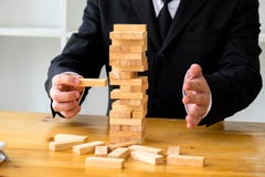 Hommes d'affaires sélectionnant des blocs de dominoe pour remplir dominos absents images stock Hommes d'affaires sélectionnant des blocs de dominoe pour remplir dominos absents images stock