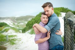 Homosexuelle Männer, die auf einem Zaun umfassen stockfoto Homosexuelle Männer, die auf einem Zaun umfassen stockfoto