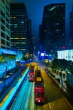 HONG KONG, CINA - 29 APRILE 2014: Vita di notte del ` s di Hong Kong Due tram rossi si passano la via con i negozi di Tiffany & d immagini stock libere da diritti HONG KONG, CINA - 29 APRILE 2014: Vita di notte del ` s di Hong Kong Due tram rossi si passano la via con i negozi di Tiffany & d immagini stock libere da diritti