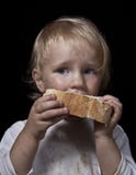 Hongerig kind die brood eten royalty-vrije stock foto Hongerig kind die brood eten royalty-vrije stock foto