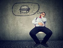 Hongerige vette bedrijfsmens die van een hamburger dromen royalty-vrije stock foto Hongerige vette bedrijfsmens die van een hamburger dromen royalty-vrije stock foto