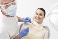 Hoog hoekportret van tandarts en glimlachende patiënt met materiaal bij kliniek royalty-vrije stock afbeeldingen Hoog hoekportret van tandarts en glimlachende patiënt met materiaal bij kliniek royalty-vrije stock afbeeldingen