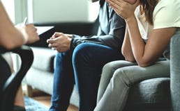 Hopeless and upset couple in therapy. Counseling or meeting with marriage counselor or adoption psychologist. Argument and dispute