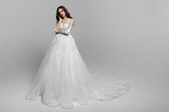 Gorgeous young woman with curly long hair in white wedding dress, make up, isolated on a white background. Copy space. royalty free stock photography Gorgeous young woman with curly long hair in white wedding dress, make up, isolated on a white background. Copy space. royalty free stock photography