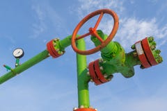 Horizontal view of a wellhead with valve armature. Oil and gas industry concept. Oil valve with rocking in the background. stock photography Horizontal view of a wellhead with valve armature. Oil and gas industry concept. Oil valve with rocking in the background. stock photography