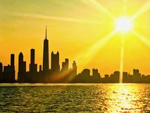 Horizonte de Chicago visto del lago Michigan, con la puesta del sol y los rayos de sol extendiendo sobre paisaje urbano durante v fotografía de archivo libre de regalías Horizonte de Chicago visto del lago Michigan, con la puesta del sol y los rayos de sol extendiendo sobre paisaje urbano durante v fotografía de archivo libre de regalías