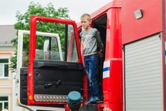 HORKI, BELARUS - 25 JUILLET 2018 : Le garçon regarde hors de la voiture rouge de service de délivrance 112 des vacances en parc u photos libres de droits HORKI, BELARUS - 25 JUILLET 2018 : Le garçon regarde hors de la voiture rouge de service de délivrance 112 des vacances en parc u photos libres de droits