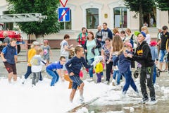 HORKI, BELARUS - 25 JUILLET 2018 : Les enfants de différents âges jouent avec la mousse blanche en parc à une partie dans le jour photo libre de droits HORKI, BELARUS - 25 JUILLET 2018 : Les enfants de différents âges jouent avec la mousse blanche en parc à une partie dans le jour photo libre de droits