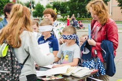 HORKI, BIELORRUSIA - 25 DE JULIO DE 2018: Los pequeños muchachos con los ojos vendados dibujan en el documento sobre una tabla en fotos de archivo HORKI, BIELORRUSIA - 25 DE JULIO DE 2018: Los pequeños muchachos con los ojos vendados dibujan en el documento sobre una tabla en fotos de archivo