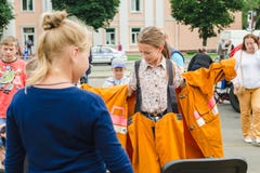 HORKI VITRYSSLAND - JULI 25, 2018: Den lilla blonda flickan klär en orange dräkt av räddareservicen 112 på en sommardag i en folk arkivbilder HORKI VITRYSSLAND - JULI 25, 2018: Den lilla blonda flickan klär en orange dräkt av räddareservicen 112 på en sommardag i en folk arkivbilder