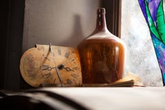 Horloge antique et la vieille bouteille près d'un mur de fenêtre images stock Horloge antique et la vieille bouteille près d'un mur de fenêtre images stock