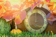 Horloge dans les feuilles d'automne colorées comme symbole du changement de temps photos libres de droits Horloge dans les feuilles d'automne colorées comme symbole du changement de temps photos libres de droits