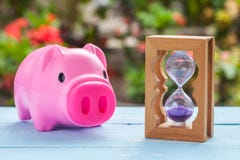 Horloge de sablier ou de sable sur le bois et le pigbank image libre de droits Horloge de sablier ou de sable sur le bois et le pigbank image libre de droits