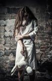 Horror Style Shot: Scary Monster Girl With Moppet Doll In Hands Stock Photo