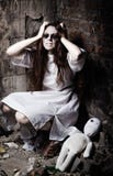 Horror style shot: strange crazy girl and her moppet doll stock image Horror style shot: strange crazy girl and her moppet doll stock image