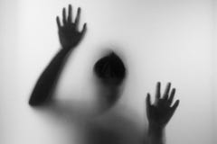 Horror woman behind the matte glass in black and white. Blurry hand and body figure abstraction.Halloween background.Black and whi Stock Photo Horror woman behind the matte glass in black and white. Blurry hand and body figure abstraction.Halloween background.Black and whi Stock Photo