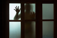 Horror woman behind the window glass in black and white. Blurry stock photography Horror woman behind the window glass in black and white. Blurry stock photography