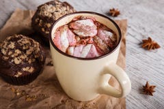 Hot chocolate with marshmallows and cupcakes on a table background. Coffee and muffins. Winter cafe desserts. stock photography Hot chocolate with marshmallows and cupcakes on a table background. Coffee and muffins. Winter cafe desserts. stock photography