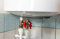 Hot and cold water taps on electric water heating boiler stock images Hot and cold water taps on electric water heating boiler stock images